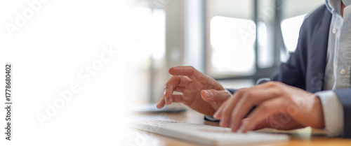 Close-up of businessman hands typing on wireless keyboard in modern office, representing productivity, remote work, and digital business communication.