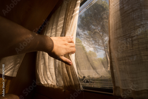 Soft morning light enters through a curtain in a quiet camper van
