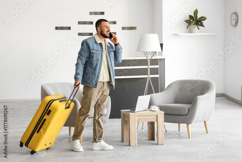 Young man with suitcase tal...