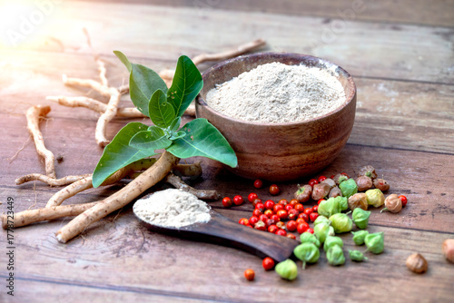 Ashwagandha Roots and powder known as Withania somnifera in white bowl on wooden background. Indian ginseng, poison gooseberry, or winter cherry. Herbal adaptogen ayurvedic medicine.