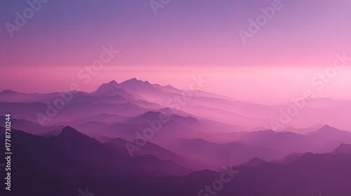 Layered mountain ranges fade into a soft pink and purple atmospheric horizon