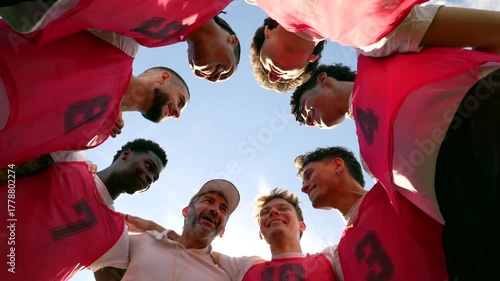 Soccer team and coach huddling together before a game