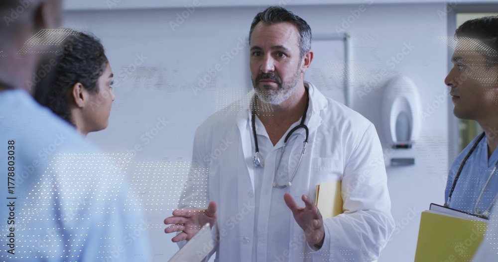 Obraz premium Doctor in lab coat gesturing with stethoscope and folder in corridor with whiteboard dispenser