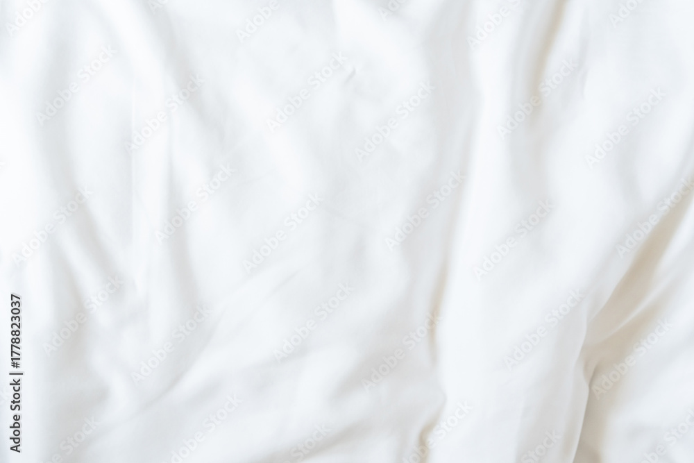 Obraz premium White bedsheet background, bed sheet cotton fabric texture, wrinkled duvet, crumpled satin blanket comforter cloth used in hotel, resort or home interior for bedding sleep comfort