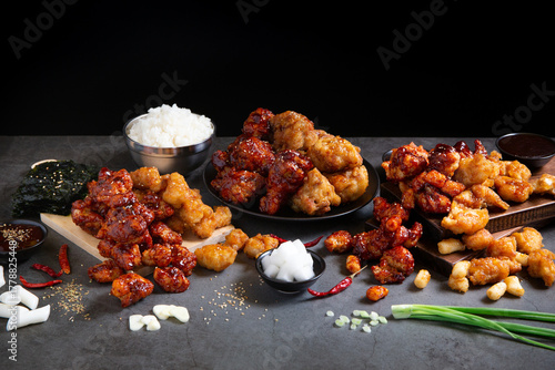 Crispy Korean Fried Chicken with Spicy Chili Sauce and Garlic Sauce on Black background.
