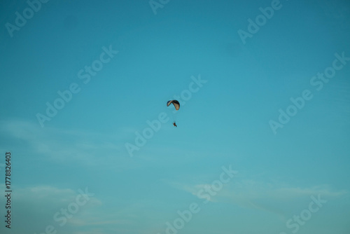Paraglider Soaring Alone Against a Clear Blue Sky