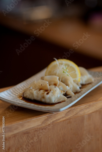Gyoza or dumplings snack with soy sauce and lemon.