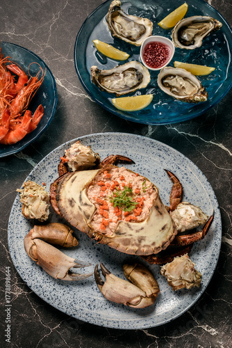 Sapateira Recheada traditional Portuguese stuffed crab meal with mixed seafood side dishes on gourmet restaurant table in Lisbon Portugal
