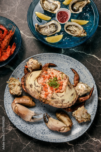 Sapateira Recheada traditional Portuguese stuffed crab meal with mixed seafood side dishes on gourmet restaurant table in Lisbon Portugal