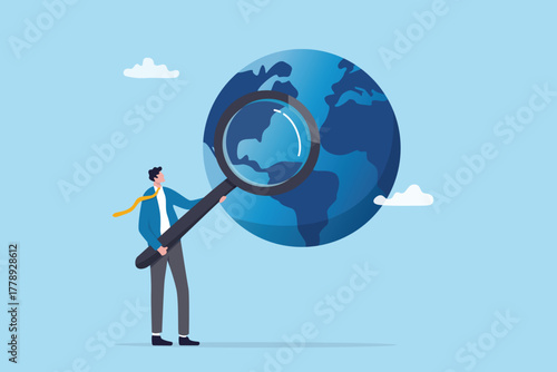 Global world economics analysis, international or oversea business research, investment or opportunity statistics, analyze profit investment portfolio, businessman analyze world with magnifying glass.