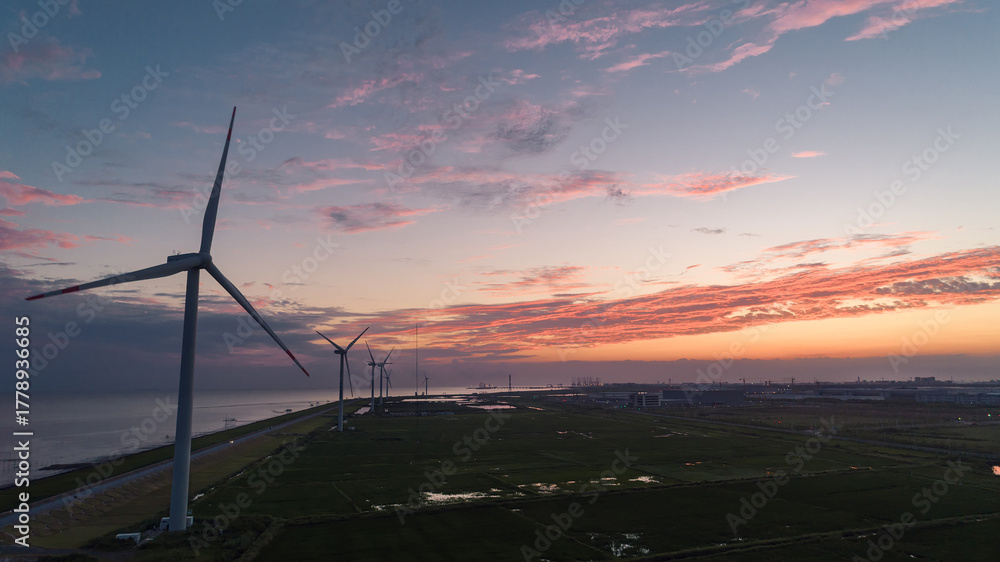 Obraz premium Aerial Sunset View of Coastal Windmills Against Flaming Sky