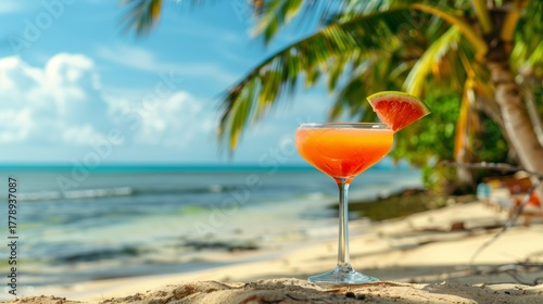 Colorful beach cocktail with grapefruit slice under palm tree on sunny shore
