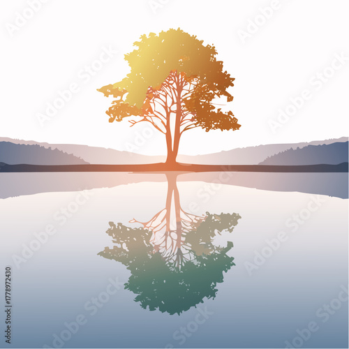 solitary tree reflected in the still waters of a foggy lake at sunrise