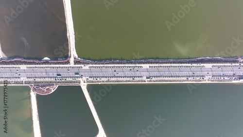 Aerial view of colorful salt ponds divided by roads, creating a geometric pattern of contrasting hues and textures, Yuncheng, China.