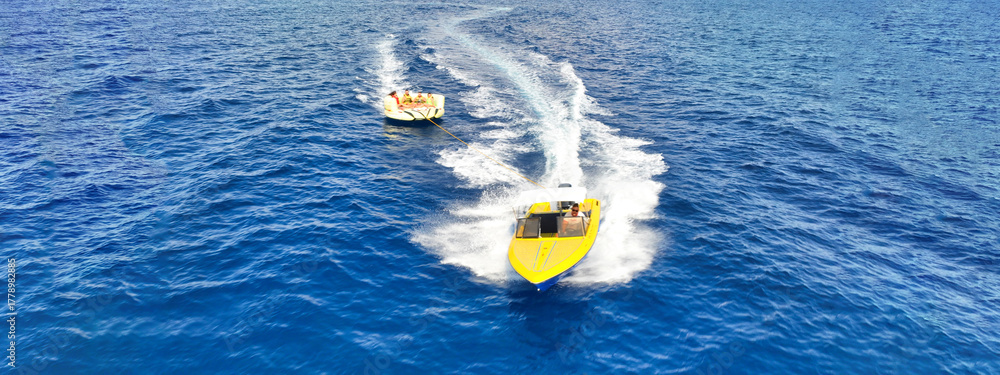 Naklejka premium Aerial drone ultra wide panoramic photo of extreme power boat donut water-sports cruising in high speed in tropical emerald bay