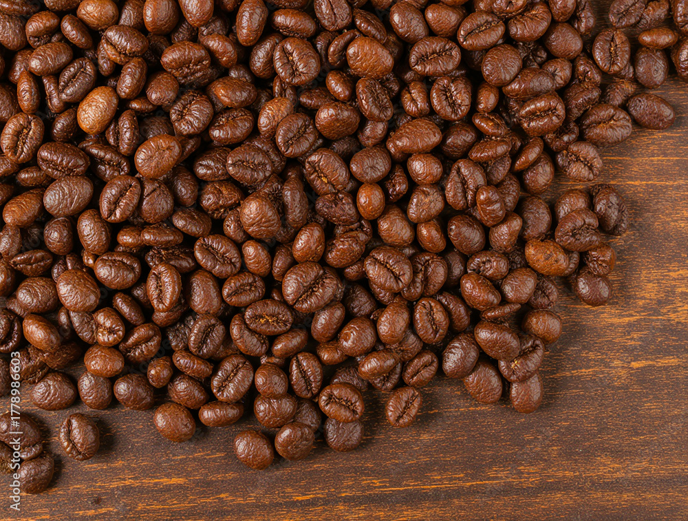 Naklejka premium Close up of roasted coffee beans on a wooden surface