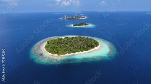 Aerial view of islands with lush greenery surrounded by turquoise waters, contrasting with the deep blue ocean, Kendhoo, Baa Atoll, Maldives.