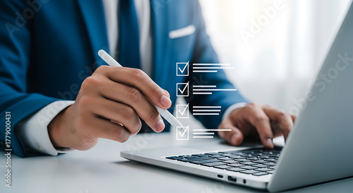 Businessman using stylus on laptop to complete checklist, indicating tasks completed and business process management.