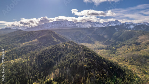 Fototapeta Naklejka Na Ścianę i Meble -  Aerial view of wooded hills and snowy Tatra mountain range, Poland
