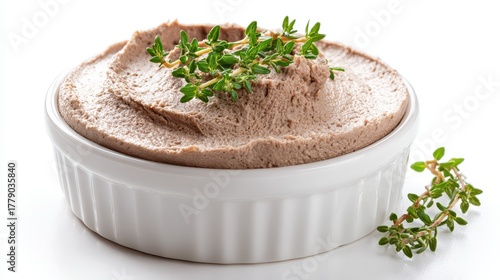 Smooth chicken liver pate in white ramekin garnished with fresh thyme herbs on white background, gourmet appetizer spread for elegant dining
