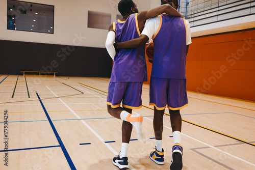 Foto Basketball teammate supporting injured player with sportsmanship and care