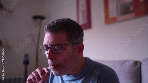 A reflective man enjoys vaping in a cozy setting, promoting calm, contemplation, and wellness