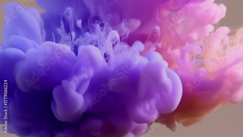 Slow motion purple, pink, orange ink dissolving in water. Color paint drops in water, abstract color mix.