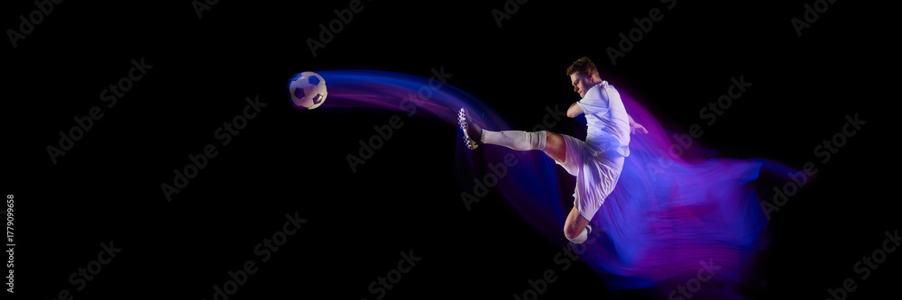 Fototapeta premium Football player performing kick with ball trajectory motion blur. Concept of athletic performance, movement analysis, and design visuals for sports gear promotion and education. Banner