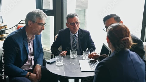 Diverse business professionals at corporate meeting, using a laptop to discuss strategy, review data, and collaborate on a project. Successful teamwork and planning. Dealing project with customer