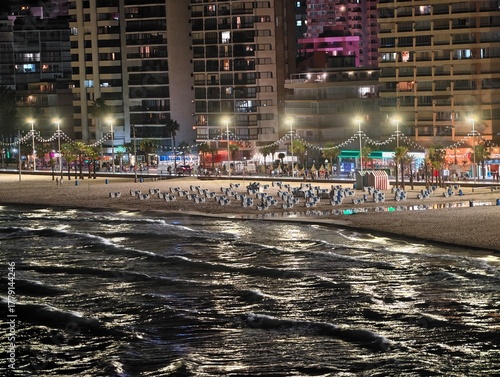 Canvas Print bustling oceanfront promenade bathed in neon glow with dancing and reflections o