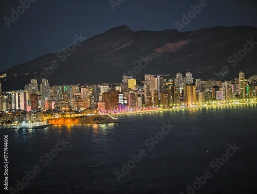 Valokuva bright coastlines with distant mountains, sparkling shoreline lights beneath mou