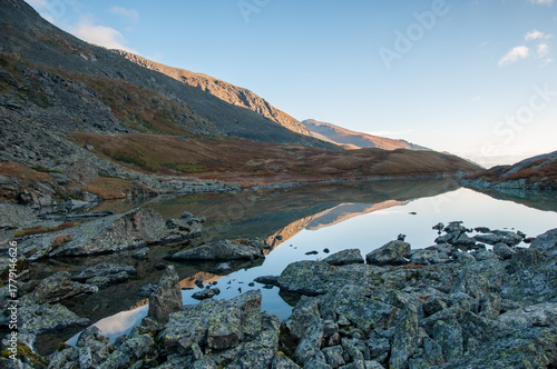 Early morning view of lake Lower Akchan, its shoreline covered with huge boulders, the Altai Republic, Russian Federation