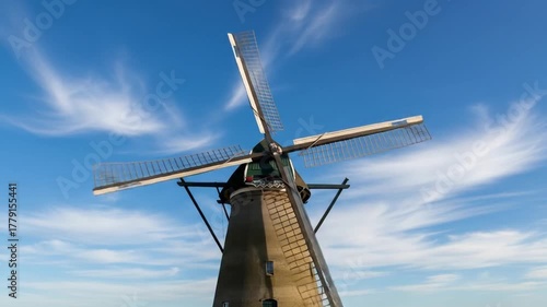 Historic Kinderdijk Windmills Turning Slowly Against a Blue Sky in the Netherlands Beautiful Scenery