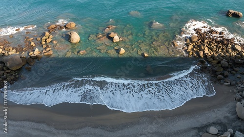 Aerial view of the beautiful turquoise ocean shoreline featuring rocks waves and sandy beach nature scenery