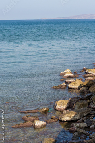 Sunny day on a rocky beach, with calm sea