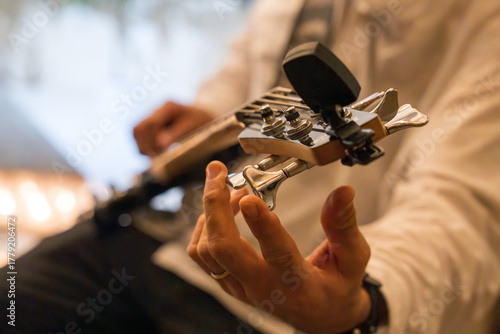 Hands tuning an electric guitar