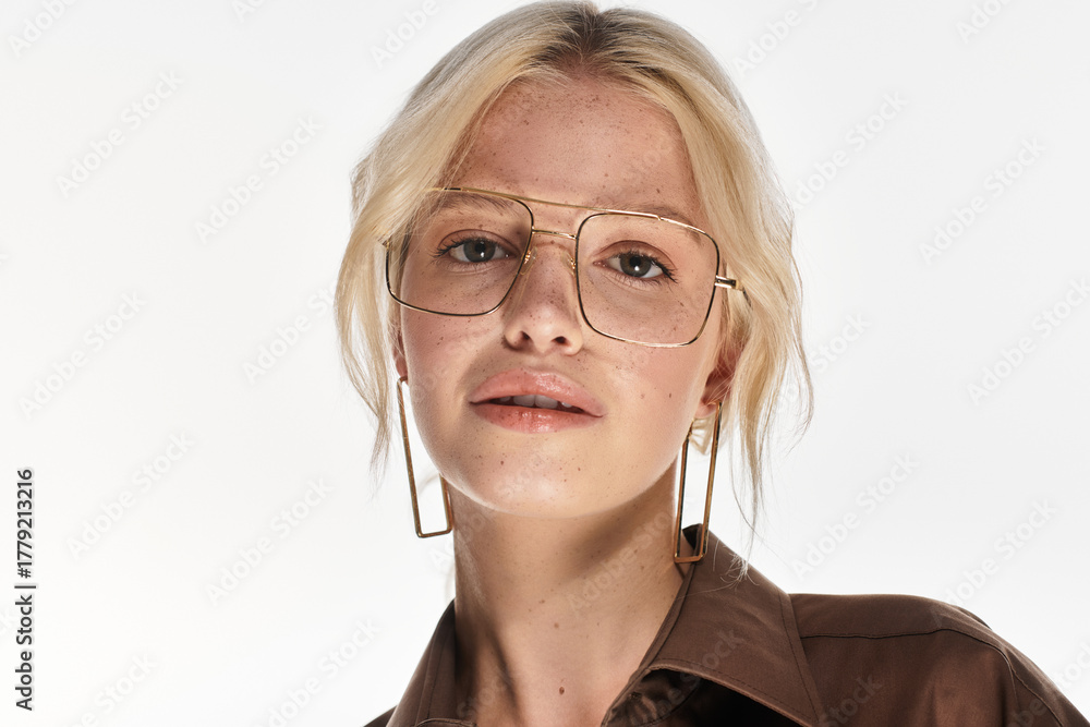 Fototapeta premium Stylish blonde woman showcasing winter fashion in a bright studio setting