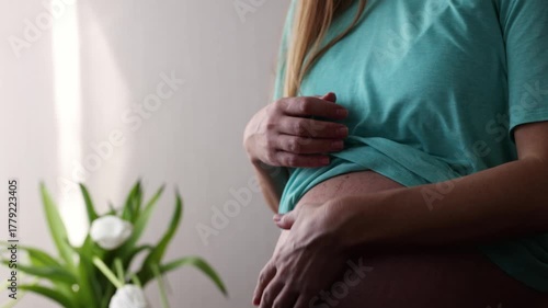 Pregnant woman gently scratching her big naked belly while baby is moving in. 4K