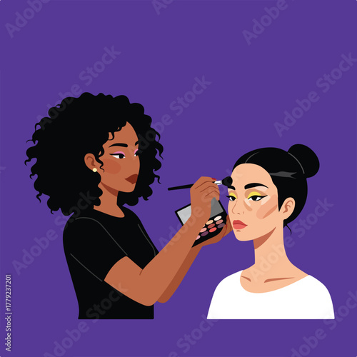 A dark-skinned woman applying makeup to a light-skinned woman's face with brush and palette, on purple