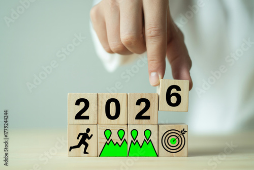 Hand arranging wooden blocks to change the year from 2025 to 2026