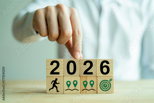A person sets the 2026 future goals on wooden blocks for business planning