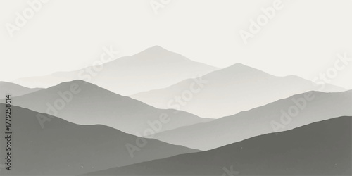 Misty blue mountain peaks and hills in the fog at sunrise, with a vast sky and cloud landscape view