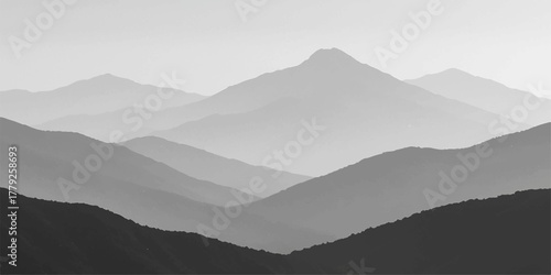 Misty blue mountain landscape view at sunrise with a cloudy sky and forest in the valley