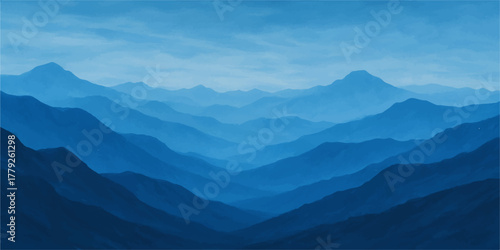 Majestic mountain landscape at sunrise with clouds and fog filling the valley below a blue sky