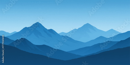 Sunrise illuminates a vast mountain landscape with clouds and fog filling the valley below a blue sky