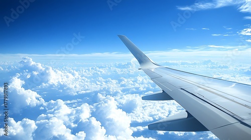 Airplane wing above fluffy clouds blue sky aerial view high resolution photo