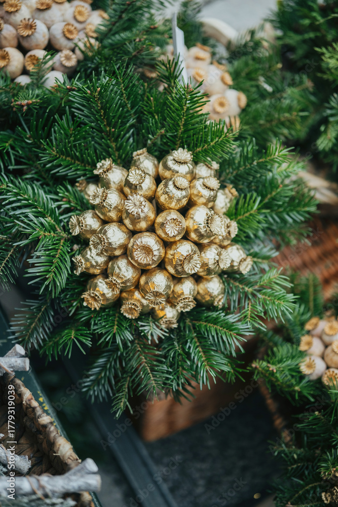 Obraz premium Evergreen branches with golden seed pods decoration, close up view, natural elements