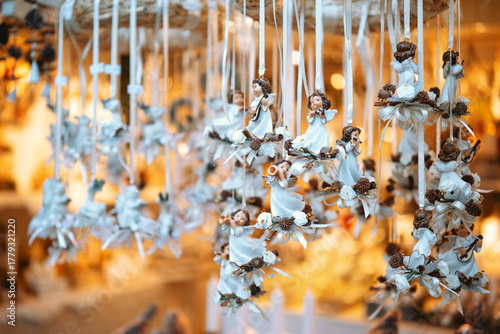 Wallpaper Mural Small angel figurines with wings hang on white ribbons, adorned with pinecones and flowers. Torontodigital.ca