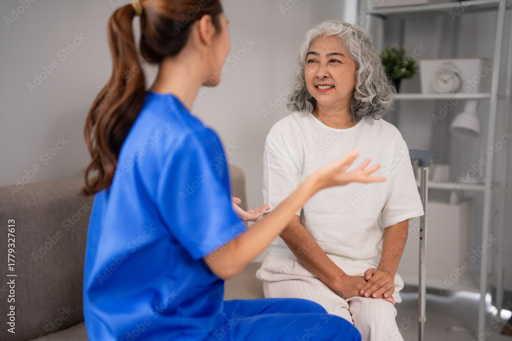 Obraz premium Asian adult nurse talks older patient home healthcare support professional visit elderly woman well-being senior care comfort communication residential living