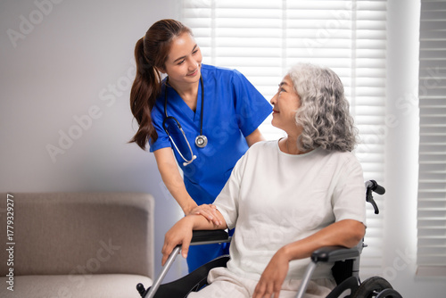 Fotografie Asian adult nurse provides compassionate home care for older woman in wheelchair
